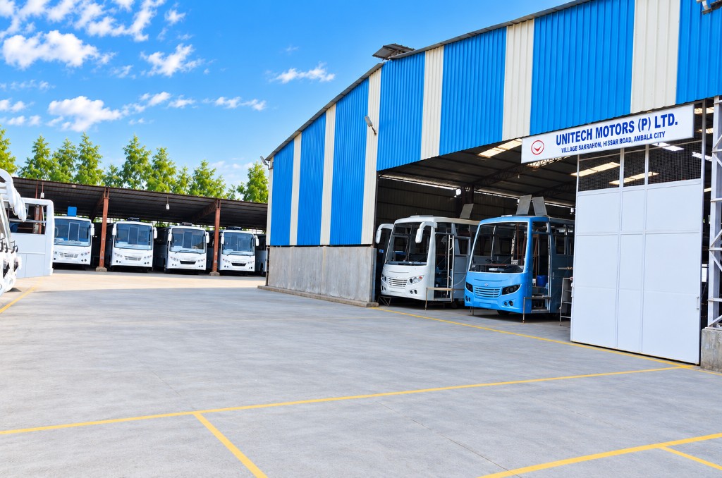 The Unitech Motors plant at Village Sakrahon, Ambala City — buses under the main shed beside the company signboard